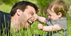 Imagem de pai e filho brincando na grama